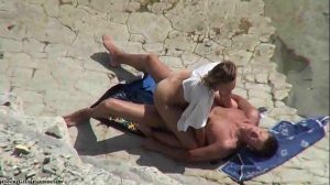 Ehefrau reitet ihren Mann am Strand